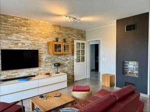 a living room with a couch and a tv on a brick wall at Villa Grande Fewo Enjoy We 2 in Göhren-Lebbin