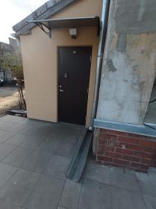 a black door on a building with a brick wall at Robezu apartments 14 in Riga