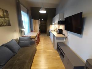 a living room with a couch and a kitchen with a table at Robezu apartments 14 in Riga