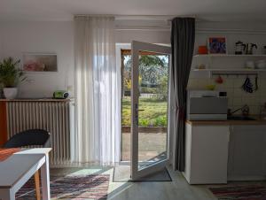 a kitchen with a door open to a yard at Ferienwohnung am Waldrand, Hitzacker in Hitzacker