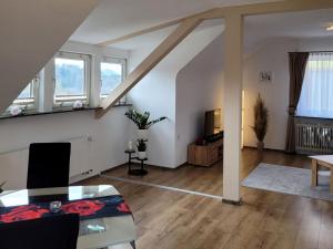 a living room with white walls and wooden floors at Ferienwohnung Amano in Fischbach