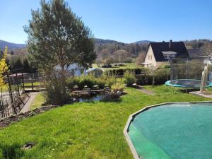 a backyard with a swimming pool and a yard with a pool at Ferienwohnung Amano in Fischbach +7 photos