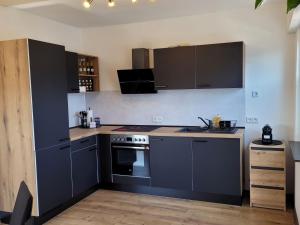 a kitchen with black cabinets and a stove top oven at Ferienwohnung Amano in Fischbach