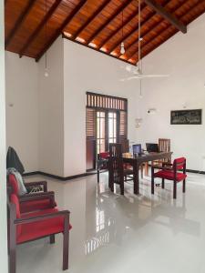a dining room with red chairs and a table at AR 7 Villa Mirissa in Matara