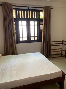 a bedroom with a large bed and a window at AR 7 Villa Mirissa in Matara