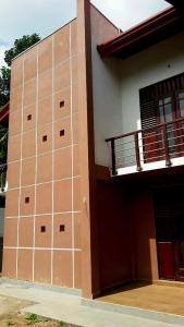 a brown and white building with a balcony at AR 7 Villa Mirissa in Matara