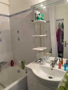 a bathroom with a sink and a tub and a mirror at Pause Soleil in Gruissan +14 photos