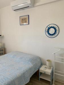 a bedroom with a bed and a clock on the wall at Pause Soleil in Gruissan