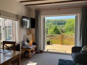 a living room with a sliding door to a deck at The Dale - Luxurious annexe with stunning view in Buckden