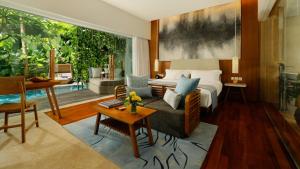 a bedroom with a bed and a living room at Maya Sanur Resort & Spa in Sanur
