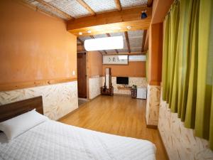 a bedroom with a bed and a living room at Ddlanchae Guesthouse - New Tower in Jeonju