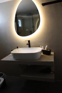 a bathroom with a white sink and a mirror at Despina's apts in Kalamariá +28 photos