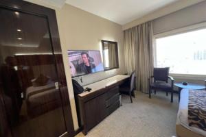a hotel room with a bed and a desk with a mirror at El Mohandseen Cairo Hotel in Cairo