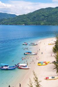 a group of people on a beach with boats at Black Win Hotel Phu Yen in Mỹ Hòa (1)