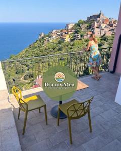 a woman standing on a balcony looking at the ocean at Domus Mea, Case Vacanza Vista Mare vicino Taormina in Forza dʼAgro
