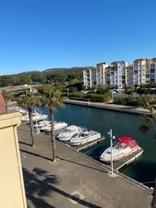 a group of boats docked in a marina with buildings at Pause Soleil in Gruissan