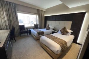 a hotel room with two beds and a window at El Mohandseen Cairo Hotel in Cairo