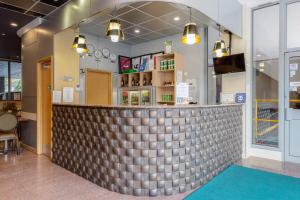 a bar in a restaurant with a tile wall at Eurotraveller Hotel - Premier - Harrow in Harrow