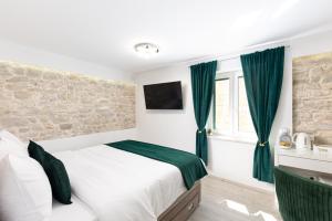 a bedroom with a bed and a stone wall at Lions Heritage Rooms in Split