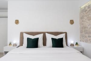 a bedroom with a large bed with green and white pillows at Lions Heritage Rooms in Split