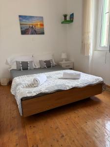 a bed in a bedroom with a wooden floor at Alechimmo Authentic Corfiot Style House - 2 Bedrooms - Split Level in Lefkimmi