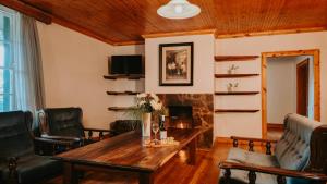 a living room with a table and a fireplace at Oregon House in Riebeek-Wes