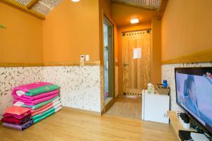 a living room with a tv and a pile of towels at Ddlanchae Guesthouse - New Tower in Jeonju +130 photos