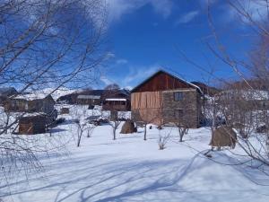 an old barn in a snow covered field at Sky Tusheti in Omalo