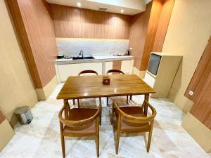 a kitchen with a wooden table and chairs and a sink at Alzetta Hotel by Abiza in Timuran