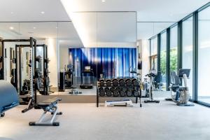 a gym with treadmills and exercise equipment and windows at Royal Savoy Hotel & Spa in Lausanne