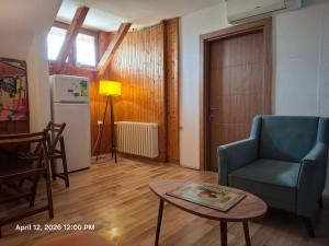 a living room with a blue chair and a table at Garden Vila in Gevgelija