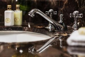 lavabo con grifo y espejo en Four Seasons Hotel The Westcliff en Johannesburgo