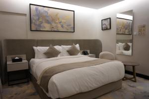 a bedroom with a large bed and two mirrors at Royal Palace Hotel - Al Olaya in Riyadh +48 photos