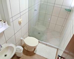 a bathroom with a shower and a toilet and a sink at Duplex 11 Pessoas-Churrasqueira-Próximo ao Mar in Itapema +16 photos
