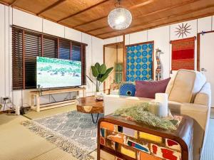 a living room with a couch and a flat screen tv at PolePole in Takamatsu