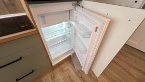 an empty refrigerator with its door open in a kitchen at A2 - Viel Platz für alle in Wernigerode