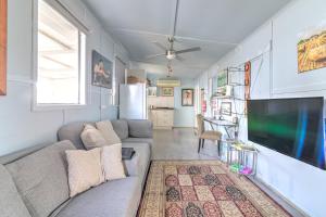 a living room with a couch and a flat screen tv at Zamenhof River Cabin - Peaceful Farm Escape - Pets Welcome in Yass