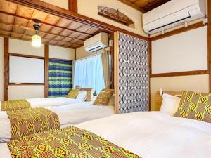 a hotel room with three beds and a window at PolePole in Takamatsu