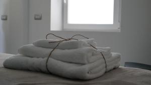 a stack of towels sitting on top of a bed at A Casa Mia 2.0 in Saronno