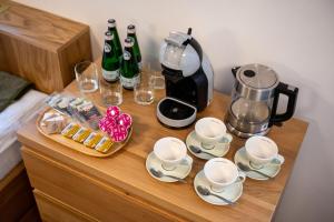 a table with a coffee maker and cups and wine bottles at Majláthova Chata Popradské Pleso in Vysoké Tatry +25 photos
