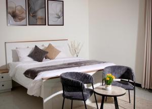 a bedroom with a bed with two chairs and a table at رخاء للغرف الفندقية in Firq +19 photos