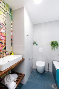 a white bathroom with a sink and a toilet at דירת סטודיו שקטה עם גקוזי בלב ראשלצ in Rishon LeẔiyyon +15 photos