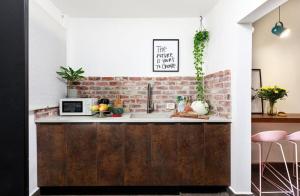a kitchen with a counter and a brick wall at דירת סטודיו שקטה עם גקוזי בלב ראשלצ in Rishon LeẔiyyon