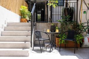 a patio with a table and chairs and stairs at דירת סטודיו שקטה עם גקוזי בלב ראשלצ in Rishon LeẔiyyon