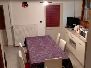 a dining room with a purple table and chairs at La Quiete in Ponte Caffaro