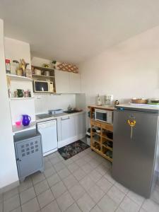 a kitchen with white cabinets and appliances in it at Sea & Relaxation Stay in Frontignan