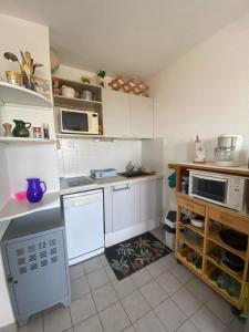 a kitchen with white cabinets and white appliances at Sea & Relaxation Stay in Frontignan +2 photos