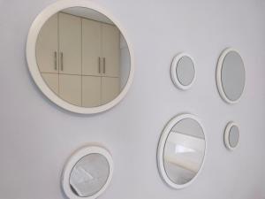 a white wall with a round mirror on it at DENNIS PATRASSO - Modern apartment in Patras in Patra