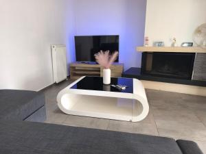 a living room with a white coffee table in front of a tv at DENNIS PATRASSO - Modern apartment in Patras in Patra