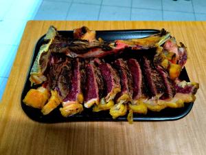 a tray of meat and vegetables on a table at Hostal Viña in Outes